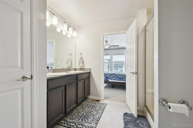 19221 E 65th Ave, Denver, CO 80249 - bathroom featuring connected bathroom, double vanity, a shower stall, and a ceiling fan