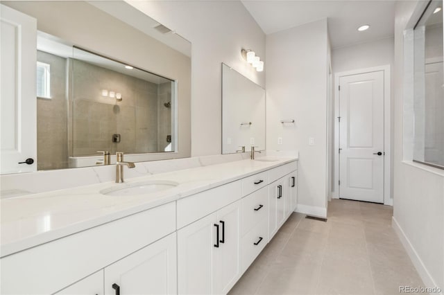 bathroom with tiled shower, vanity, and tile patterned floors