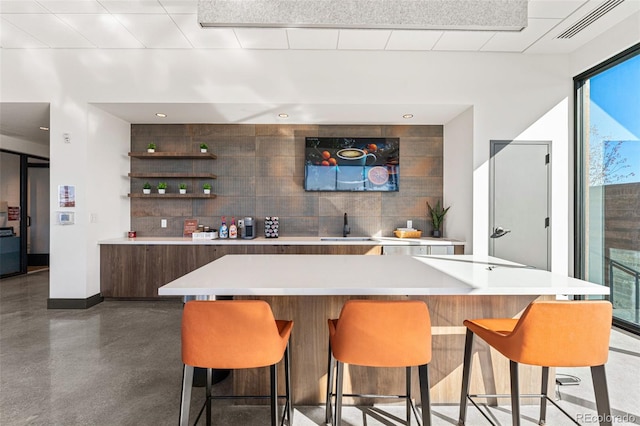 bar featuring decorative backsplash and sink