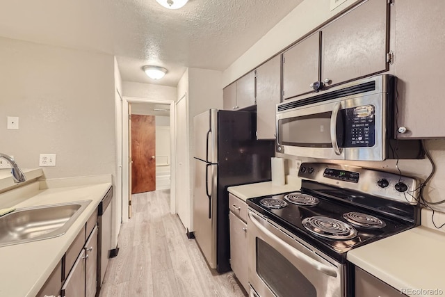 8853 Colorado Blvd Unit A-106, Thornton, CO 80229 - kitchen with stainless steel appliances, a textured ceiling, light wood finished floors, and light countertops