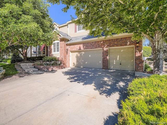 6577 S Waco Way, Aurora, CO 80016 - view of property hidden behind natural elements with brick siding, driveway, and an attached garage