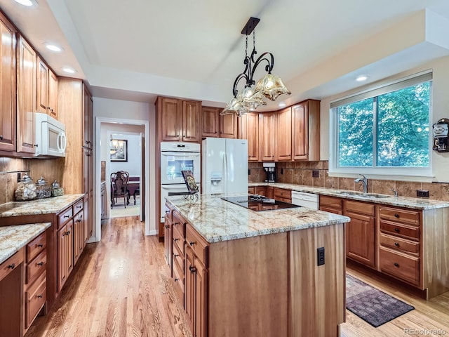 6577 S Waco Way, Aurora, CO 80016 - kitchen featuring white appliances, light wood-style floors, tasteful backsplash, a center island, and light stone countertops