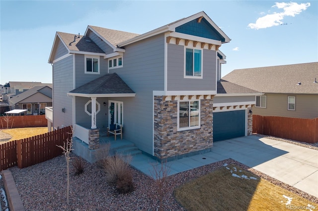 craftsman house with an attached garage, a shingled roof, fence, concrete driveway, and stone siding