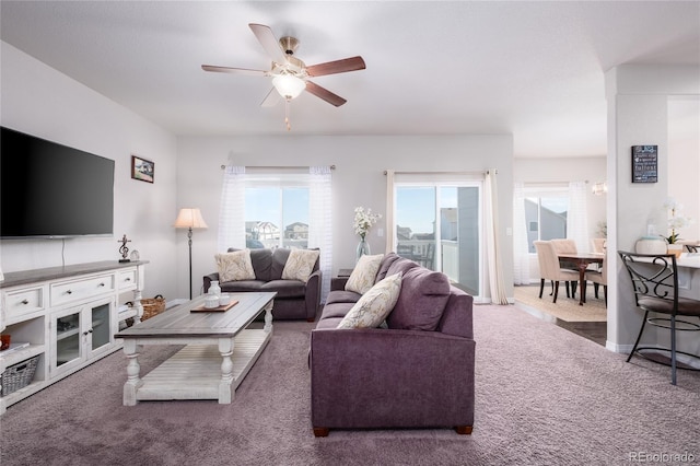 carpeted living area featuring ceiling fan