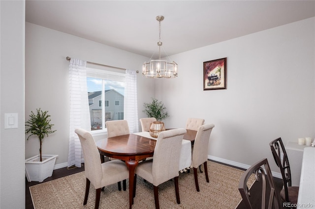 dining room with a chandelier, baseboards, and wood finished floors