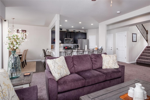 living area featuring baseboards, stairway, and recessed lighting