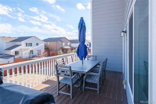 deck with outdoor dining area and a residential view