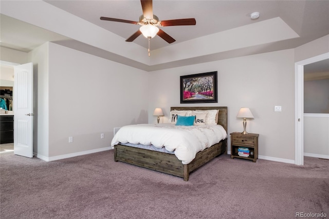 carpeted bedroom with ceiling fan, a raised ceiling, and baseboards