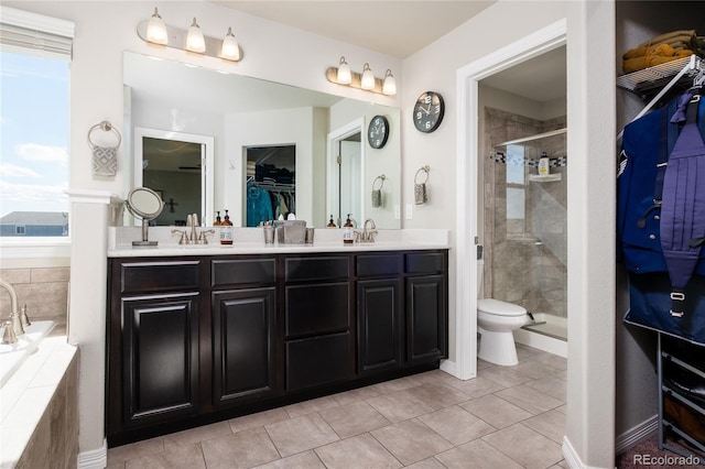 bathroom featuring a sink, a spacious closet, a bath, double vanity, and a stall shower