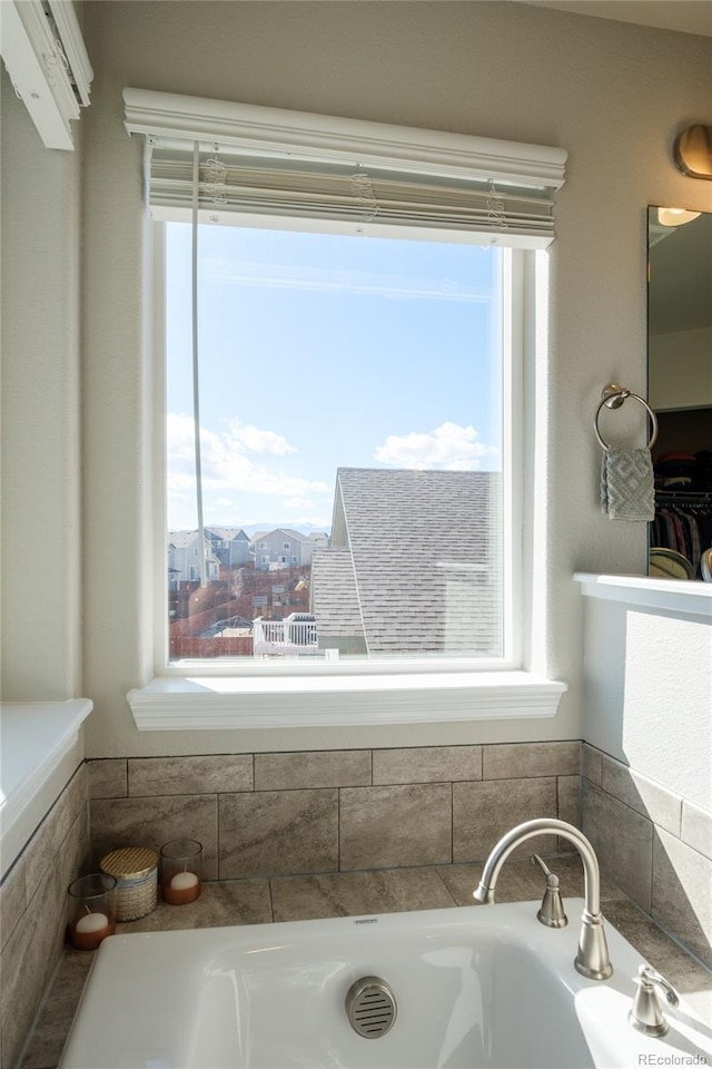 full bathroom featuring a garden tub and a wealth of natural light