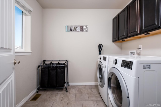 washroom with light tile patterned floors, visible vents, baseboards, independent washer and dryer, and cabinet space