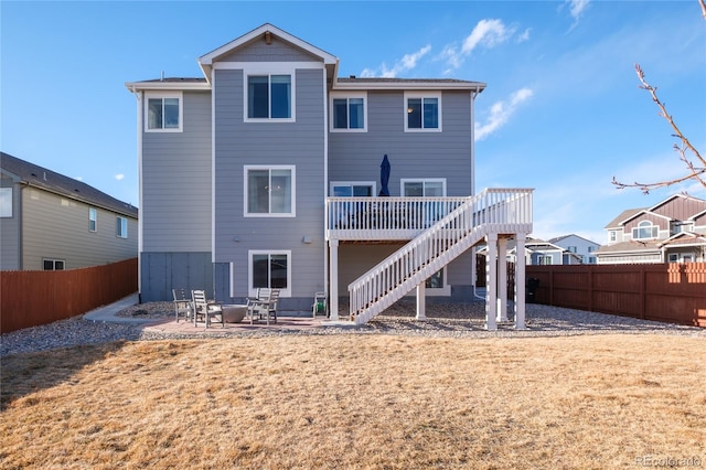 rear view of property featuring a yard, a patio, stairway, a deck, and a fenced backyard