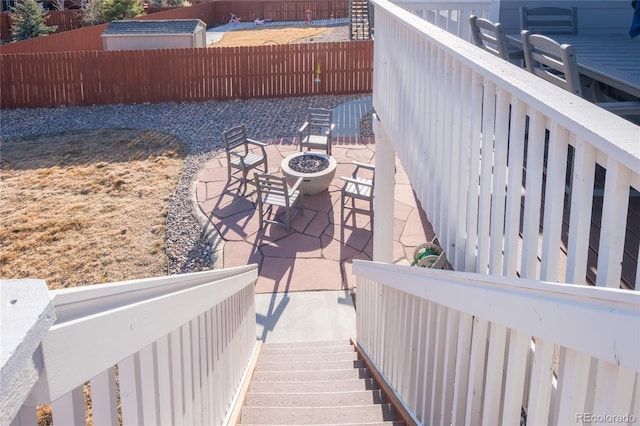 view of patio with an outdoor fire pit and fence