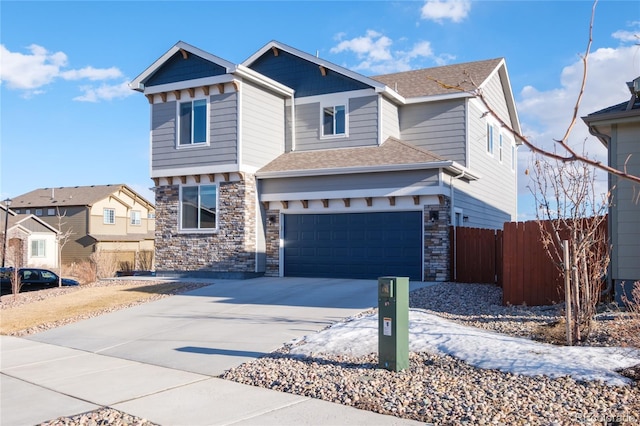 view of front of home with stone siding, concrete driveway, fence, and an attached garage