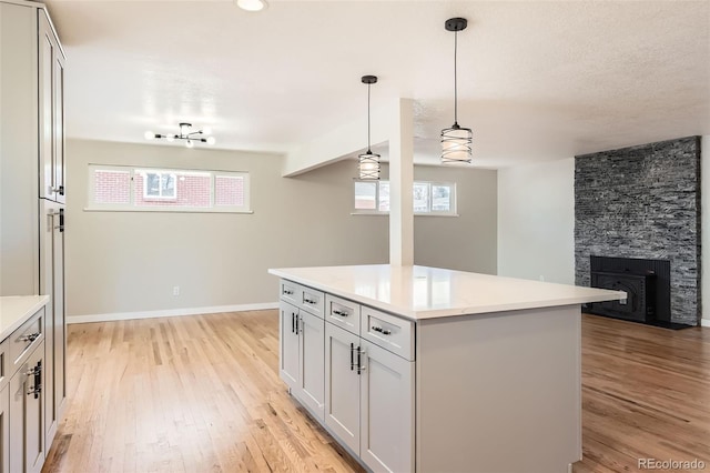 kitchen featuring pendant lighting, light wood-style flooring, and light countertops