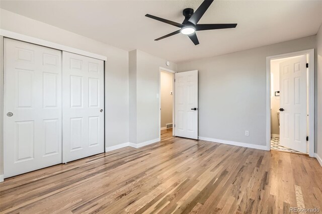 unfurnished bedroom featuring a closet, light wood-type flooring, and baseboards