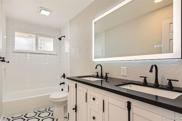 bathroom with toilet, a textured wall, shower / bathtub combination, and a sink