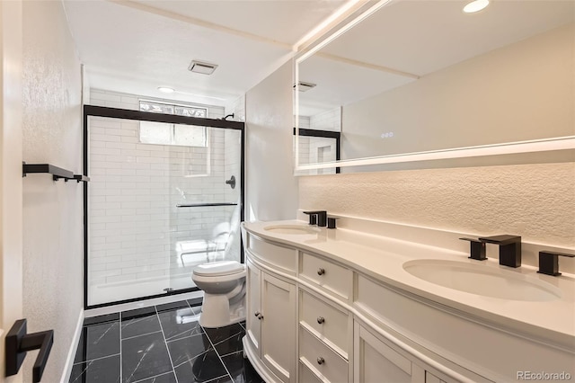 full bathroom featuring visible vents, toilet, a stall shower, a sink, and double vanity