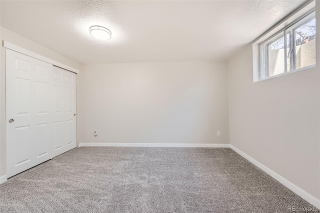 unfurnished bedroom featuring carpet flooring, baseboards, and a textured ceiling