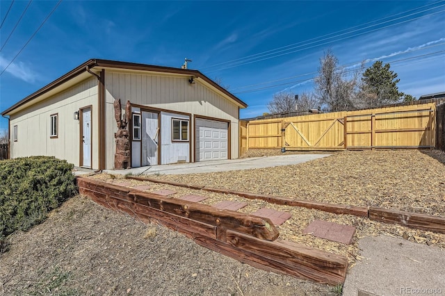 exterior space with a gate, fence, and a garage