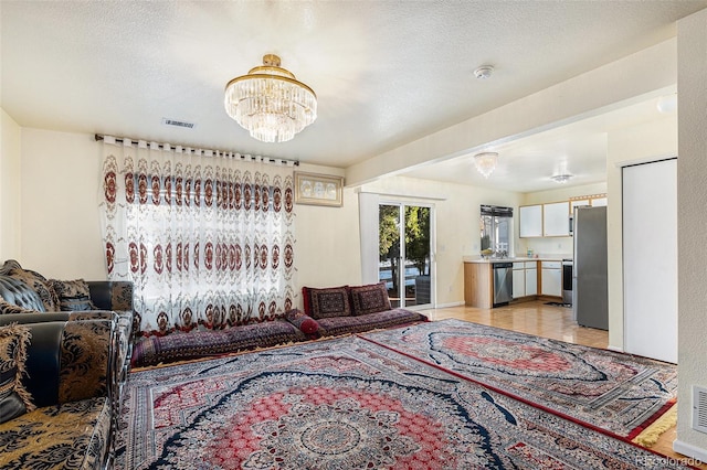 living room with a textured ceiling and a notable chandelier