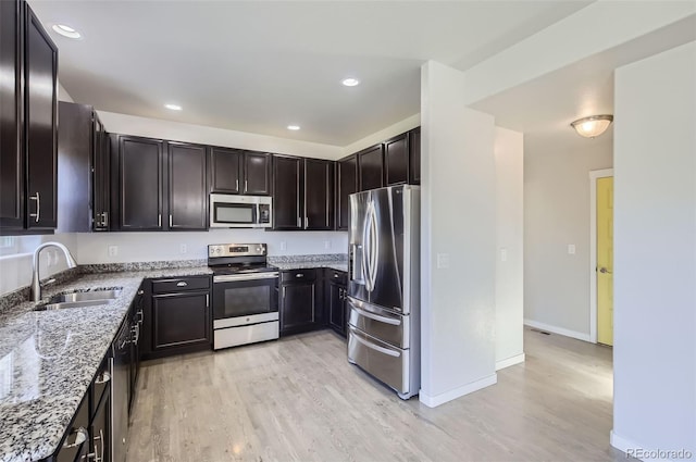 1464 Moraine Valley Dr, Severance, CO 80550 - kitchen with stainless steel appliances, light stone countertops, light wood-style flooring, and recessed lighting