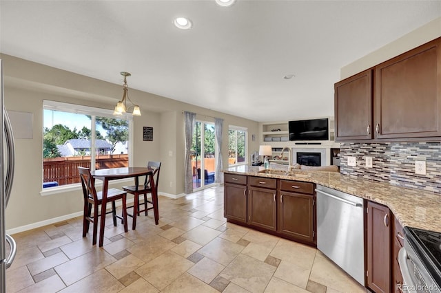 5415 Spruce Ave, Castle Rock, CO 80104 - kitchen with appliances with stainless steel finishes, a peninsula, backsplash, recessed lighting, and open floor plan