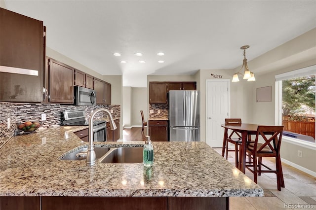 5415 Spruce Ave, Castle Rock, CO 80104 - kitchen featuring appliances with stainless steel finishes, decorative backsplash, a peninsula, recessed lighting, and light stone counters