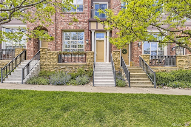 10311 Belvedere Ln, Lone Tree, CO 80124 - view of front facade featuring brick siding, a front lawn, and stairs