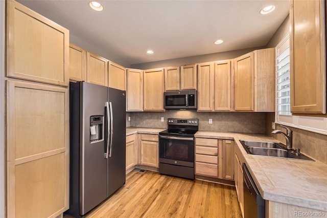 10311 Belvedere Ln, Lone Tree, CO 80124 - kitchen featuring appliances with stainless steel finishes, light brown cabinets, a sink, light wood-type flooring, and tasteful backsplash