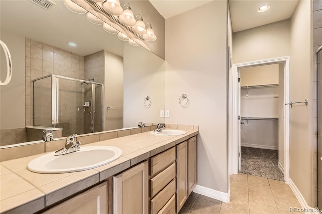 10311 Belvedere Ln, Lone Tree, CO 80124 - full bathroom featuring a spacious closet, a stall shower, double vanity, tile patterned floors, and recessed lighting