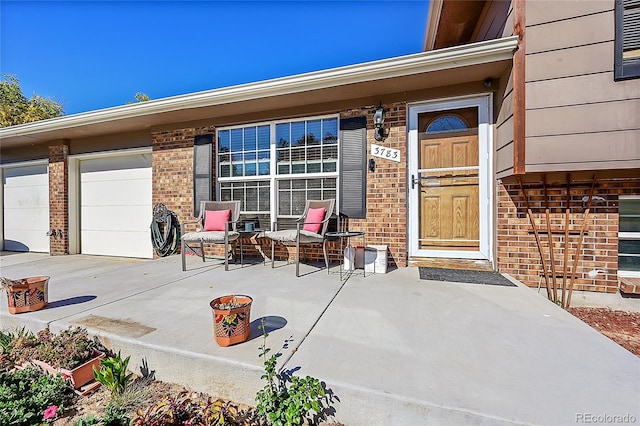 view of exterior entry with a patio area and a garage