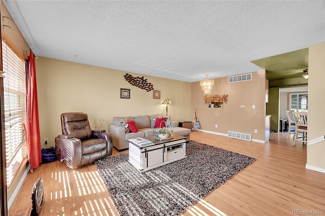 living room with a textured ceiling, wood-type flooring, and plenty of natural light