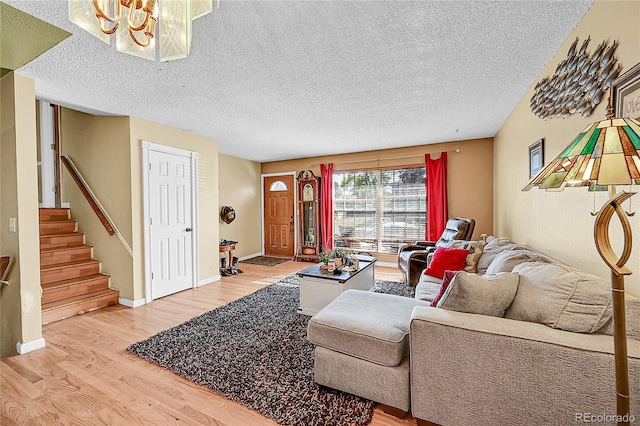 living room with an inviting chandelier, hardwood / wood-style floors, and a textured ceiling