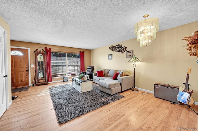 living room featuring a notable chandelier, a textured ceiling, and light hardwood / wood-style floors