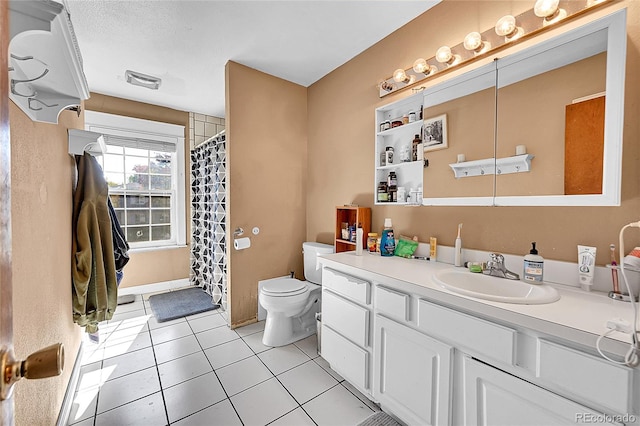 bathroom with toilet, vanity, and tile patterned flooring