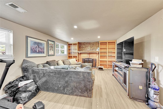 living room with a fireplace and light wood-type flooring