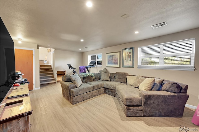 living room with light hardwood / wood-style flooring and a textured ceiling