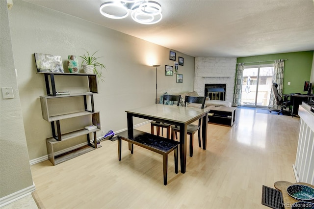 8022 S Columbine Ct, Centennial, CO 80122 - dining space with wood finished floors, a large fireplace, and a chandelier