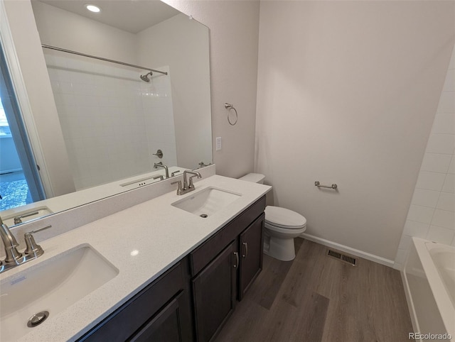 full bathroom with hardwood / wood-style floors, vanity, toilet, and tub / shower combination