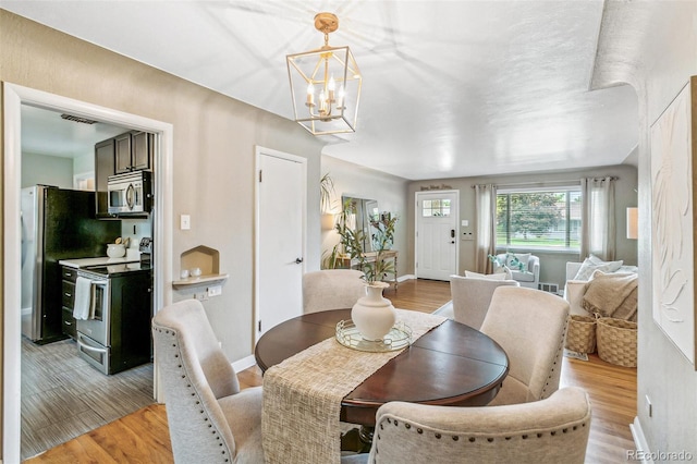 1060 S Harrison St, Denver, CO 80209 - dining space with light wood-style floors and a chandelier