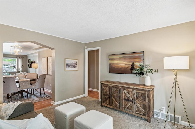 1060 S Harrison St, Denver, CO 80209 - living room with arched walkways, a chandelier, and a textured ceiling