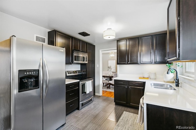 1060 S Harrison St, Denver, CO 80209 - kitchen featuring appliances with stainless steel finishes, light countertops, dark brown cabinetry, and wood finished floors