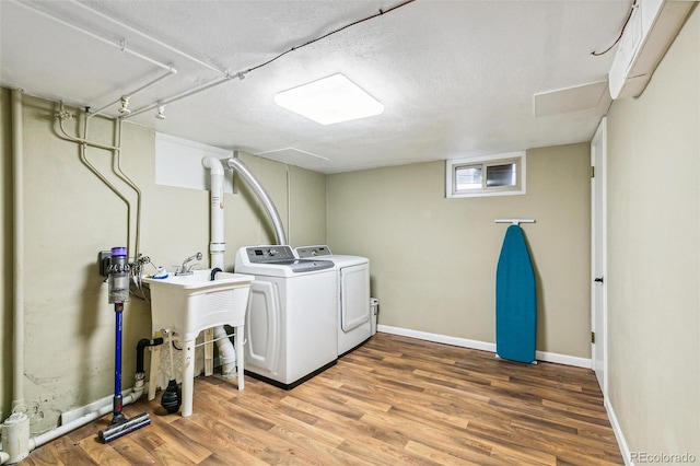 1060 S Harrison St, Denver, CO 80209 - laundry room with washer and dryer, light wood-type flooring, and a textured ceiling