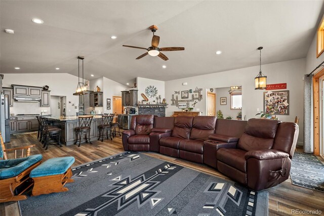 living room with dark wood-type flooring, vaulted ceiling, and ceiling fan