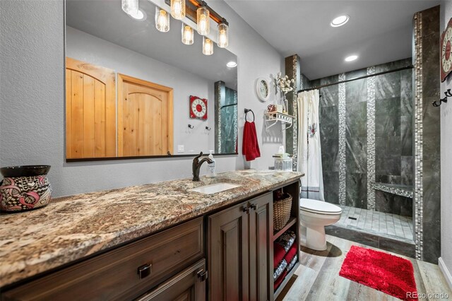 bathroom with curtained shower, wood-type flooring, vanity, and toilet