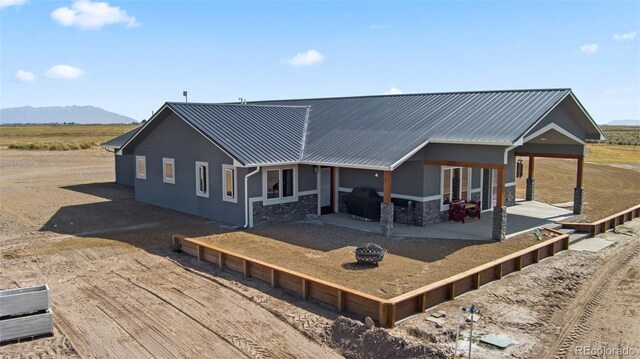 rear view of house featuring a mountain view and a patio area