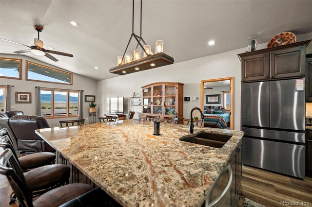 kitchen with an island with sink, lofted ceiling, sink, appliances with stainless steel finishes, and billiards