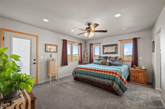 carpeted bedroom featuring multiple windows and ceiling fan