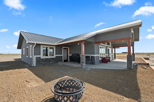 view of front of house featuring an outdoor fire pit and a patio